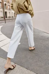 Jeans de tiro alto con diseño wide leg y corte cropped. Presenta cinco bolsillos, cierre frontal con cremallera y botón metálico.