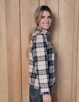 Camisa de manga larga con estampado de rayas verticales en tonos blanco y lila. Presenta cuello alto con volados, cierre frontal con doble botonadura y puños con volados.