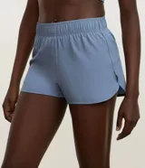 Bermuda deportiva Get Over modelo runner color beige, con cintura elástica, bajo redondeado y aberturas laterales. Cuenta con un pequeño bolsillo funcional trasero.