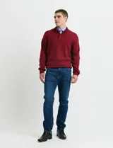 Sweater de punto color tostado, con cuello alto y cierre frontal parcial con botones. Diseño de manga larga con puños y ruedo acanalados.
