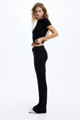 Pantalón tipo legging acampanado de punto acanalado fino, con cintura plegable y laterales fruncidos que generan un efecto drapeado.