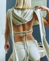 Musculosa gris a rayas horizontales con capucha y espalda descubierta. Tiene breteles regulables a los costados para atar a la espalda.
