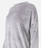 Conjunto de pijama largo de dos piezas confeccionado en tejido fleece suave y abrigado. Incluye una blusa de manga larga con cuello redondo y ajuste en la cintura, y un pantalón con cintura elástica. Ambas prendas presentan una textura grabada con diseño de gatitos.