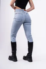 Pantalón de jean celeste de tiro alto, corte ajustado y largo hasta el tobillo.