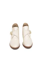 Botinetas de cuero charolado con textura croco en color off-white, con taco medio de efecto madera, punta redonda y tira lateral con hebilla metálica dorada.
