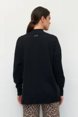 Polera color beige de manga larga con puños elastizados y aberturas laterales.