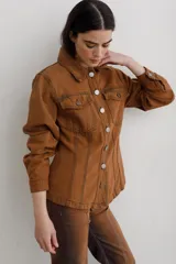 Chaqueta de denim color marrón, con corte entallado en la cintura, cierre frontal con botones metálicos y bolsillos superiores con solapa.