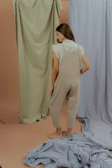 Mono enterito de lino color beige, de calce amplio y relajado, con bolsillos laterales y tirantes regulables.