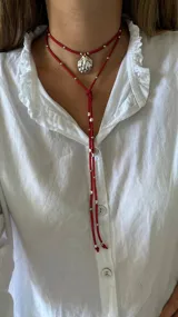 Collar de cuero azul con dije plateado en forma de caracol y detalles de cuentas plateadas. El collar tiene dos tiras que caen por el frente.