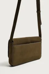 Bolso tipo bandolera de piel con acabado serraje, compartimento principal con cierre de solapa e imán, bolsillo posterior y asa de hombro ajustable.