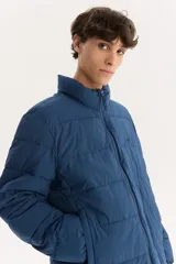 Campera puffer azul marino con cuello alto y cierre frontal con cremallera.