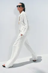 Pantalón palazzo de lino color rosado, con cintura elástica ajustable con cordón y bolsillos laterales ocultos.