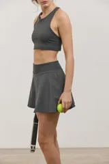Pollera deportiva corta con calza incorporada, diseñada para actividades como pádel o tenis. Cuenta con cintura ancha de ajuste cómodo y bolsillo invertido en la calza para guardar pelotas. Confeccionada en tejido liviano y elastizado.