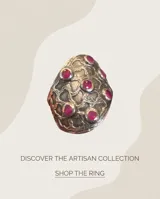 Anillo ancho de plata con diseño texturizado en relieve y pequeñas piedras circulares de rubí incrustadas.