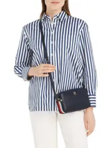 Cartera cruzada tipo bandolera Tommy Hilfiger de poliuretano color azul marino, con correa ajustable y logo metálico dorado en el frente.