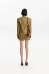 Blazer estilo chaqueta color verde oliva, con hombreras marcadas, entallado en la cintura y cierre frontal de tres botones negros.