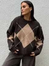 Sweater de punto con diseño de rombos en tonos gris oscuro y gris claro, de corte holgado, cuello redondo y manga larga.
