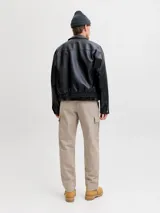 Pantalón cargo de corte relajado y tiro medio color beige, confeccionado en tejido de sarga con bolsillos laterales y traseros.