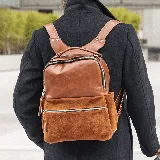 Mochila marrón de cuero vacuno con bolsillo frontal con cierre, bolsillos laterales, doble compartimento con cierre superior, interior forrado con bolsillo con cierre y bolsillo para celular.