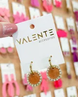 Aros colgantes con forma circular, color marrón con glitter, bordeados con strass plateados y gancho dorado.