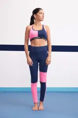 Calza deportiva azul con paneles laterales en color rosa.