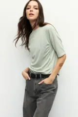 Remera de manga tres cuartos con cuello a la base, confeccionada en tela texturizada color verde menta. Presenta detalles de fruncido en ambos laterales que aportan caída y movimiento a la prenda.