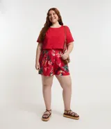 Short rojo con estampado de bananas y cocoteros, con elástico en la espalda, trabillas en la cintura, pliegues delanteros y bolsillos laterales.
