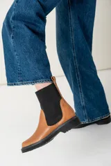 Bota color marrón con elástico negro en los laterales y suela track color negro.