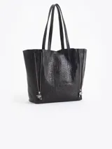 Cartera tipo shopper de cuero vacuno flor graneado, con formato amplio y estructura flexible. Presenta dos cierres verticales decorativos en el frente con tiracierres personalizados y doble manija de hombro.