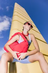 Bolso deportivo tipo duffel bag de nylon color verde oliva, con asas de mano y correa ajustable para llevar al hombro.