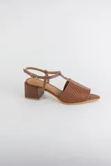 Sandalias de cuero rojo con diseño de tiras horizontales abullonadas en la parte delantera, punta fina, tira vertical central en forma de T y tira ajustable al tobillo. Poseen tacón cuadrado de madera de 6 cm.
