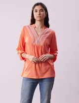 Blusa amarilla de manga 3/4 con escote en V y bordado multicolor. Largo de manga regulable con presilla y botón. Marca Ruby Rd.