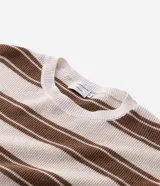 Remera de punto de manga corta con cuello redondo y diseño de rayas horizontales en tonos beige y marrón.