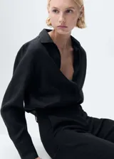 Camisa de lino negra, de manga larga con puños abotonados, cuello camisero y cierre frontal de botones.