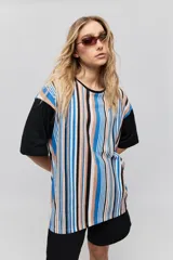 Remerón de manga corta de calce amplio y diseño de rayas verticales en tonos azul, tostado, negro y blanco, con mangas negras y cuello redondo.