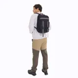 Mochila urbana Merrell modelo Gundahoo Urban Back, confeccionada en lona de poliéster color negro. Presenta un diseño funcional con correas de ajuste grises en el frente con hebillas de liberación rápida, compartimento principal con cierre de doble cursor y logo de la marca en la parte superior.