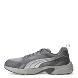 Championes Puma Milenio Tech Lt de color gris, con diseño de inspiración retro, parte superior de malla transpirable y detalles superpuestos en material sintético con la característica franja lateral de la marca en tono plateado. Cuenta con cordones grises y suela de goma amortiguada.