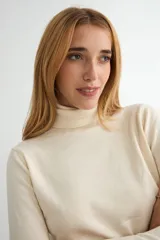 Polera de cuello alto y manga larga, confeccionada en tejido de punto fino con un diseño ajustado al cuerpo.