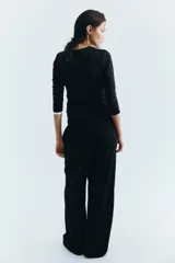 Pantalón negro de corte ancho, con cintura elástica y bolsillos laterales.