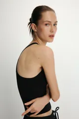 Top negro de tejido de punto, con cuello halter y corte ajustado.