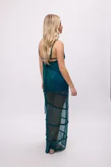 Vestido midi de tela semitransparente con acabado brillante en color verde esmeralda. Presenta un diseño con volados en los recortes, escote con cordón ajustable y breteles finos.