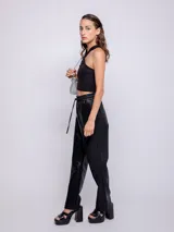 Pantalón negro de símil cuero, corte recto, con cintura elastizada ajustable con cordón y cuatro bolsillos.