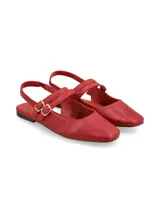 Mocasín chatita de cuero color rojo, con punta fina, suela plana y tiras cruzadas en el empeine con hebillas metálicas doradas.