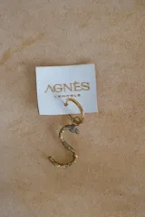 Aro individual con dije en forma de letra "S" de bronce con textura rústica y argolla dorada, de la marca Agnès Lenoble.
