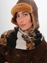 Gorro tipo aviador de cuero marrón con interior de piel sintética color beige.