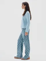 Polera de punto en color celeste, con cuello alto y manga larga. Presenta un pequeño logo bordado en el centro del pecho y terminaciones en tejido acanalado.