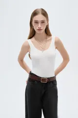 Body blanco sin mangas de poliamida, con diseño ajustado al cuerpo y cuello redondo.