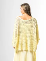 Sweater de tejido en red color amarillo mantequilla, con diseño oversize y amplio, mangas largas y caída holgada ideal para superposiciones.