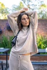 Sweater tejido con diseño de rombos geométricos en relieve, de cuello redondo y manga larga con silueta amplia.