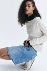 Buzo de punto fino con diseño de hombros descubiertos y escote redondo amplio. Presenta un corte holgado con terminaciones acanaladas en el cuello, los puños y el bajo.